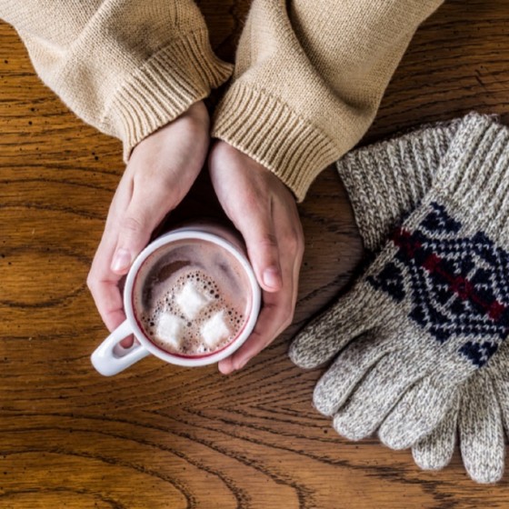 handen om een kop warme chocolademelk 