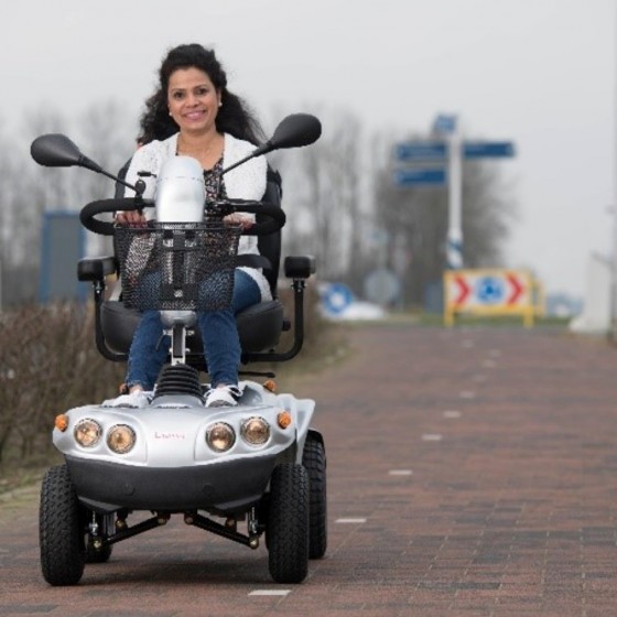 vrouw op een scootmobiel op het fietspad