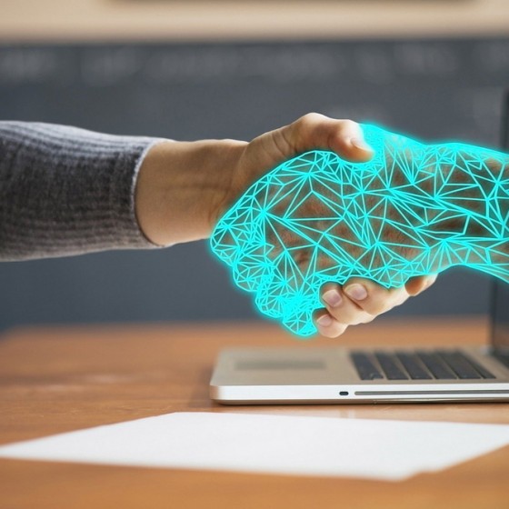 Digitale hand schud de handen met een normale hand.