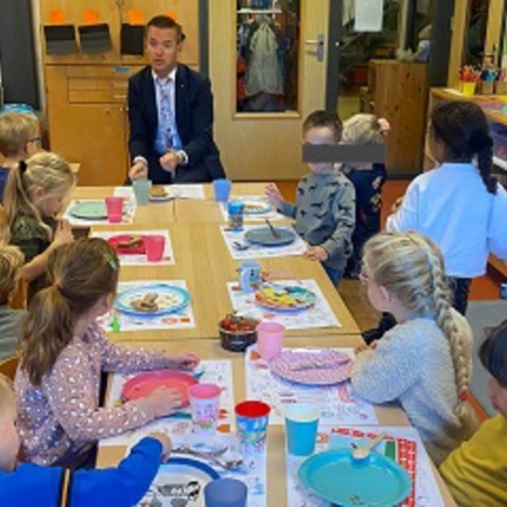 wethouder Jurgen van Houdt aan tafel bij kinderen tijdens het nationaal schoolontbijt